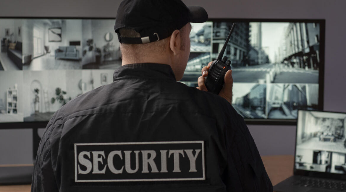 retrato guarda de seguranca masculino com estacao de radio e telas de camera